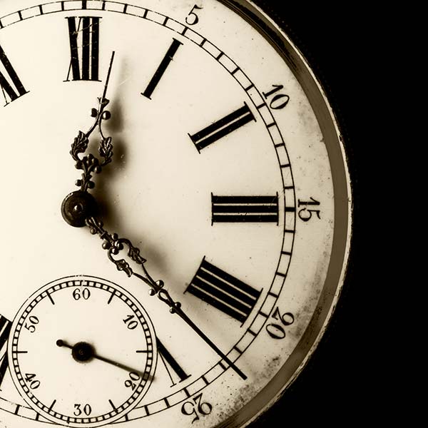 Monochromatische Nahaufnahme einer alten Uhr mit abgeschnittenem schwarzem Hintergrund